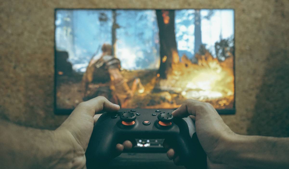 Hand holding a pc gaming controller nearby at a retail store display showing multiple controller options